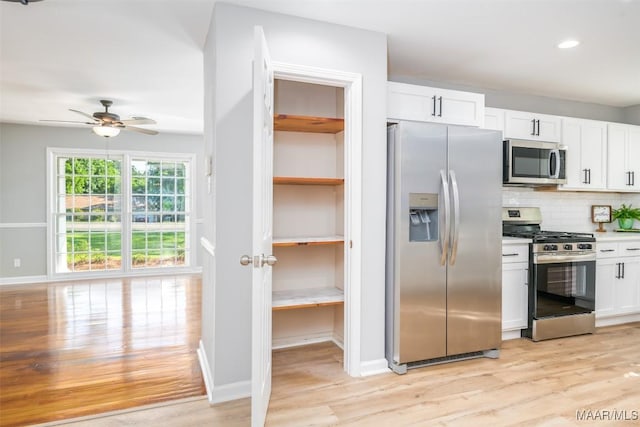 3212 Mcgehee Rd, Montgomery, AL 36111 - kitchen with stainless steel appliances, light wood-type flooring, white cabinetry, backsplash, and ceiling fan