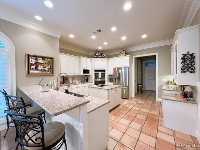 7178 Wyngrove Dr, Montgomery, AL 36117 - kitchen with stainless steel appliances, a sink, a peninsula, crown molding, and a breakfast bar