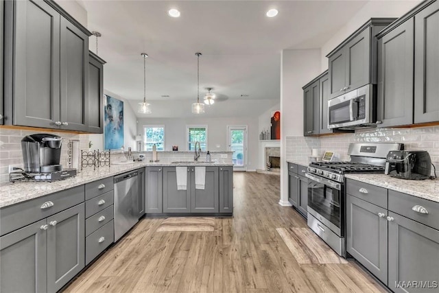 400 Lismore Pl, Montgomery, AL 36117 - kitchen with appliances with stainless steel finishes, a peninsula, a sink, light wood-style floors, and decorative backsplash