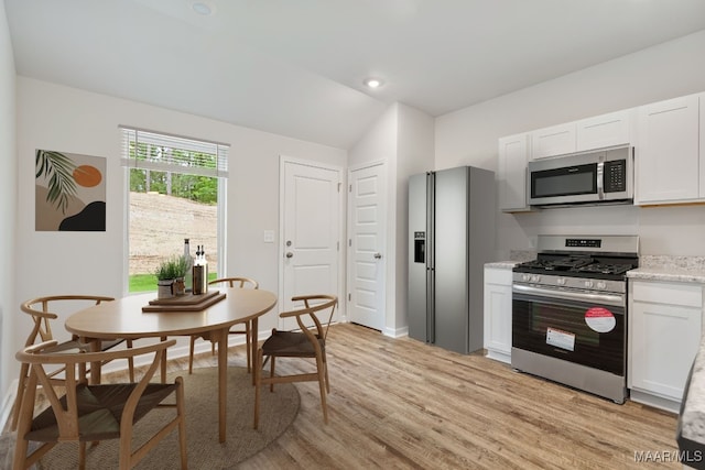 177 Canal Xing, Wetumpka, AL 36092 - kitchen featuring appliances with stainless steel finishes, lofted ceiling, light wood-type flooring, white cabinetry, and baseboards