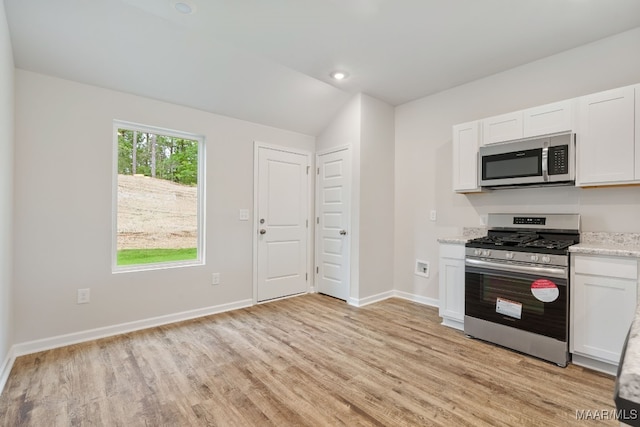 177 Canal Xing, Wetumpka, AL 36092 - kitchen featuring appliances with stainless steel finishes, light wood-type flooring, white cabinets, baseboards, and lofted ceiling