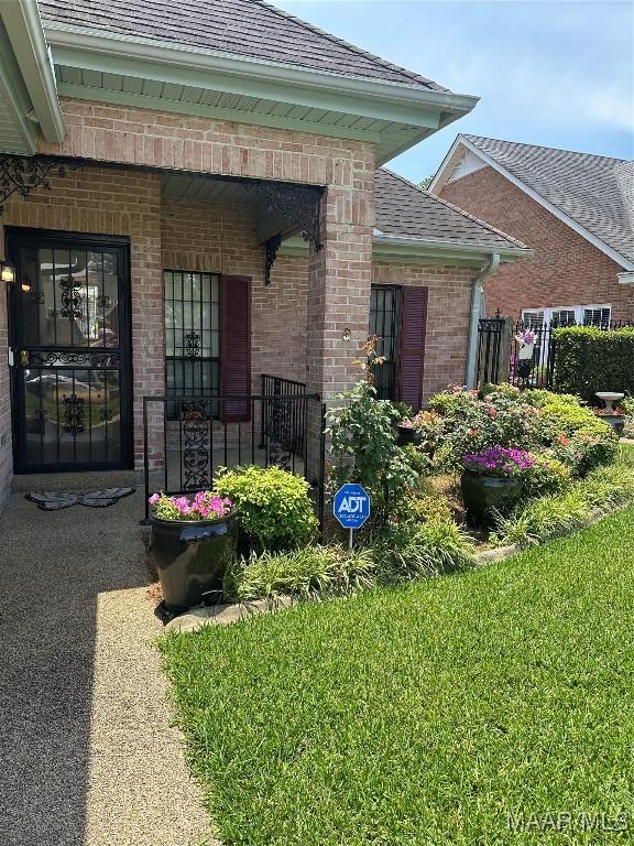 3932 Oak Ave, Montgomery, AL 36109 - property entrance featuring brick siding, a shingled roof, and a lawn