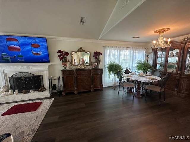3932 Oak Ave, Montgomery, AL 36109 - dining area with a chandelier, dark wood-style floors, crown molding, and a brick fireplace