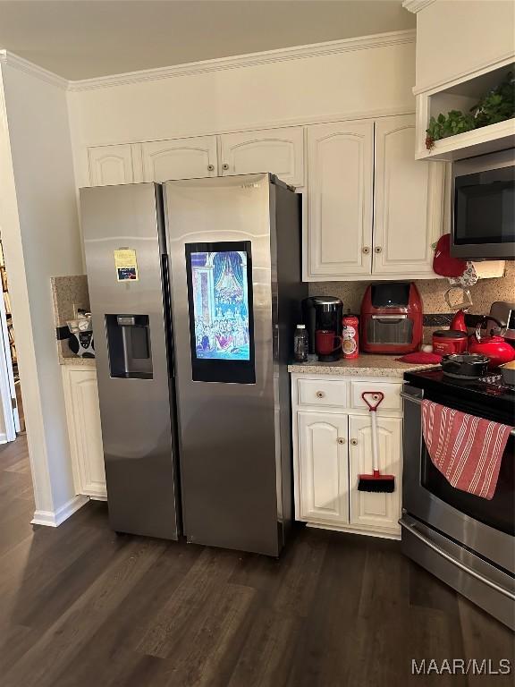 3932 Oak Ave, Montgomery, AL 36109 - kitchen featuring appliances with stainless steel finishes, crown molding, dark wood-style flooring, white cabinets, and light countertops