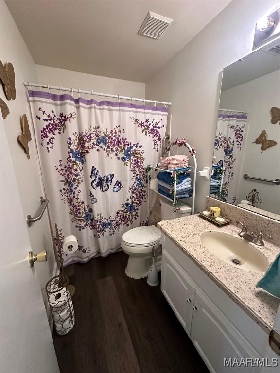 3932 Oak Ave, Montgomery, AL 36109 - bathroom with toilet, wood finished floors, vanity, and a shower with shower curtain