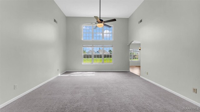 8 Honor Dr, Fort Mitchell, AL 36856 - carpeted empty room featuring a ceiling fan, arched walkways, baseboards, and a towering ceiling