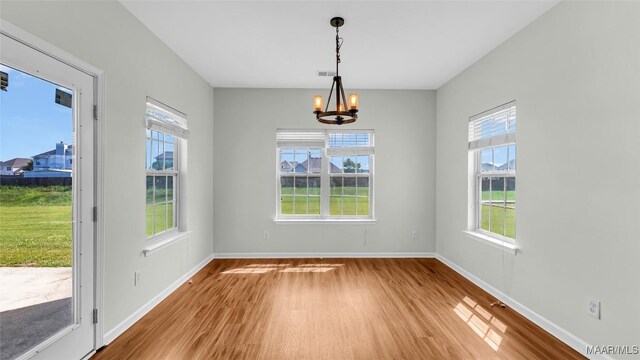 8 Honor Dr, Fort Mitchell, AL 36856 - unfurnished dining area with wood finished floors, a chandelier, healthy amount of natural light, and baseboards