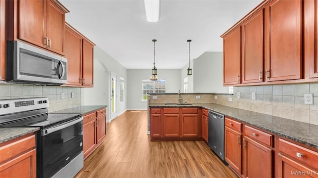 8 Honor Dr, Fort Mitchell, AL 36856 - kitchen with appliances with stainless steel finishes, a sink, light wood-type flooring, tasteful backsplash, and a peninsula