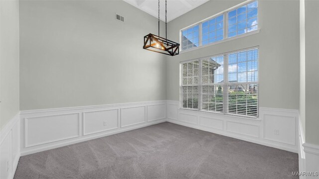 8 Honor Dr, Fort Mitchell, AL 36856 - unfurnished dining area with carpet flooring, wainscoting, and a decorative wall