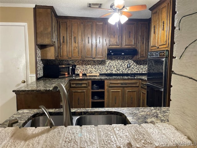1003 Keith Way, Selma, AL 36701 - kitchen with under cabinet range hood, black appliances, a ceiling fan, decorative backsplash, and crown molding