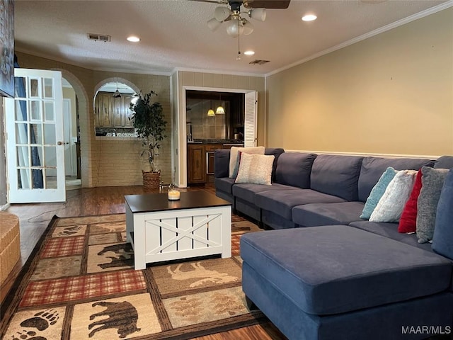 1003 Keith Way, Selma, AL 36701 - living room with wood finished floors, ceiling fan, crown molding, arched walkways, and recessed lighting