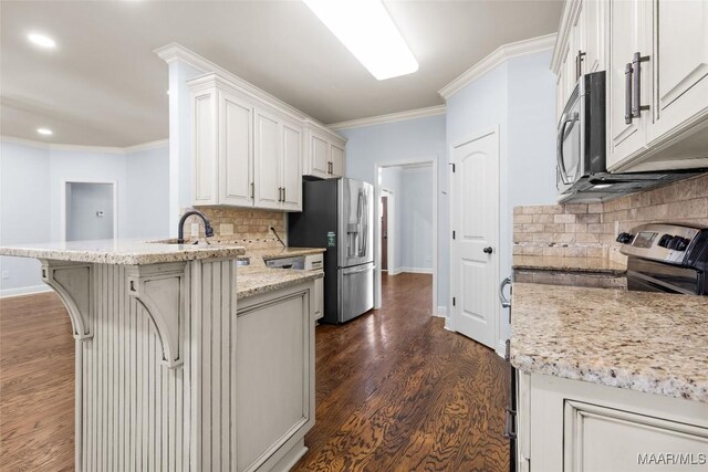 9148 Autumnbrooke Way, Montgomery, AL 36117 - kitchen with appliances with stainless steel finishes, a peninsula, crown molding, decorative backsplash, and dark wood-style floors