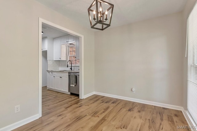 302 Janice St, Prattville, AL 36066 - unfurnished dining area with baseboards, light wood-style floors, a chandelier, and a sink