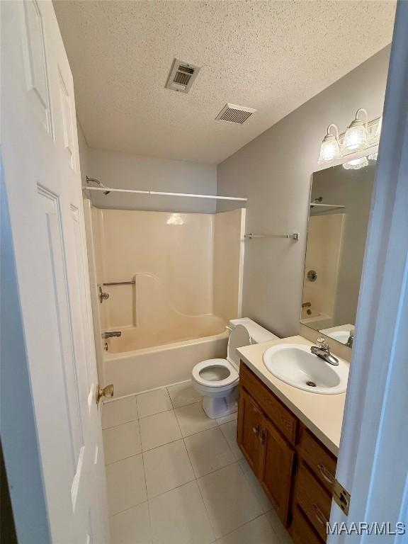 6260 Bell Gables Cir, Montgomery, AL 36117 - full bath featuring tile patterned floors, a textured ceiling, vanity, shower / tub combination, and toilet