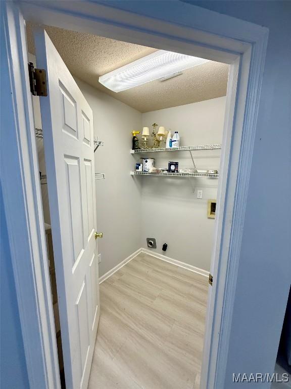 6260 Bell Gables Cir, Montgomery, AL 36117 - laundry room featuring electric dryer hookup, light wood-style floors, washer hookup, and baseboards