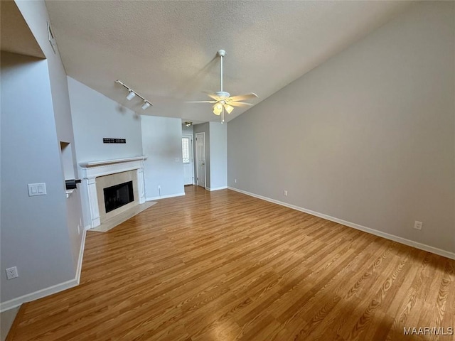 6260 Bell Gables Cir, Montgomery, AL 36117 - unfurnished living room with wood finished floors, ceiling fan, a textured ceiling, baseboards, and vaulted ceiling