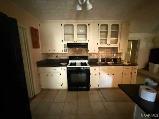 2700 W Edgemont Ave, Montgomery, AL 36108 - kitchen featuring gas stove, under cabinet range hood, a sink, dark countertops, and tasteful backsplash