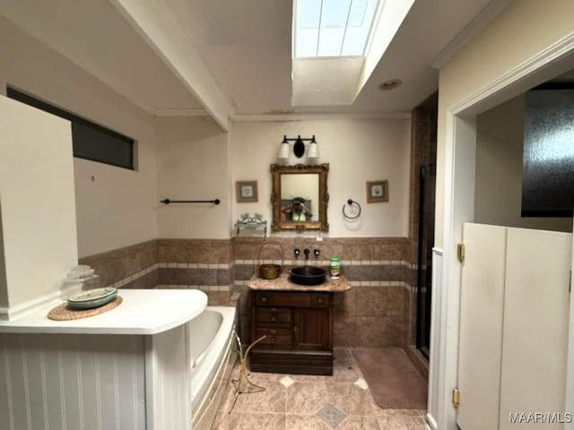 2700 W Edgemont Ave, Montgomery, AL 36108 - bathroom featuring tile walls, vanity, wainscoting, a garden tub, and tile patterned floors