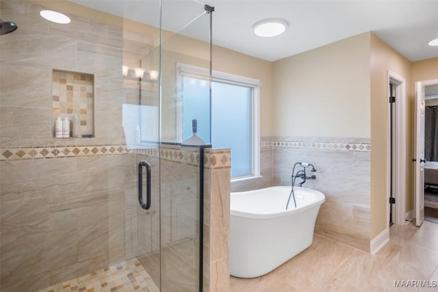 8945 Chantilly Way, Montgomery, AL 36116 - bathroom with a freestanding tub, a shower stall, tile walls, and a wainscoted wall
