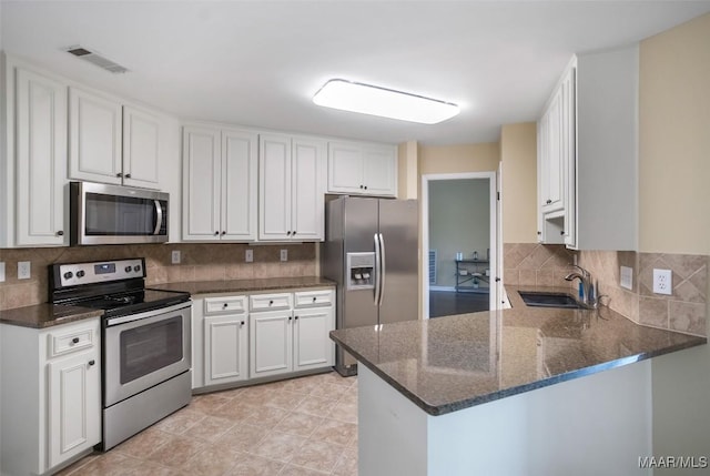 8945 Chantilly Way, Montgomery, AL 36116 - kitchen featuring stainless steel appliances, a sink, dark stone counters, and backsplash