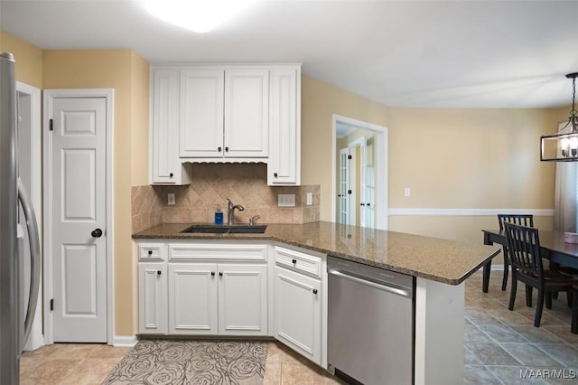 8945 Chantilly Way, Montgomery, AL 36116 - kitchen with appliances with stainless steel finishes, a sink, white cabinetry, a peninsula, and decorative backsplash
