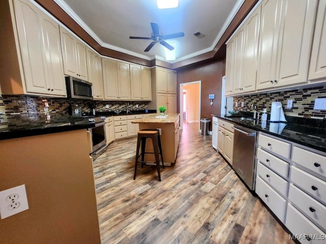 103 River Chase Ct, Wetumpka, AL 36092 - kitchen with appliances with stainless steel finishes, a ceiling fan, ornamental molding, light wood finished floors, and tasteful backsplash
