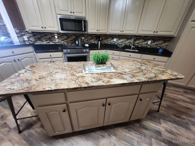 103 River Chase Ct, Wetumpka, AL 36092 - kitchen featuring stainless steel appliances, a breakfast bar area, dark wood-style floors, a sink, and backsplash