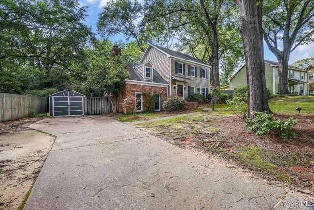 184 Fox Hollow Rd, Montgomery, AL 36109 - view of front of home with a detached garage, asphalt driveway, and a chimney