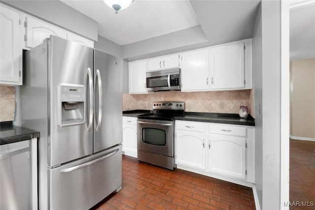 184 Fox Hollow Rd, Montgomery, AL 36109 - kitchen featuring stainless steel appliances, dark countertops, white cabinetry, tasteful backsplash, and brick patterned flooring
