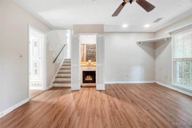 184 Fox Hollow Rd, Montgomery, AL 36109 - unfurnished living room with baseboards, light wood-style flooring, stairway, a ceiling fan, and a fireplace
