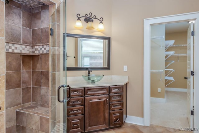 8460 Rockbridge Cir, Montgomery, AL 36116 - bathroom with a shower stall, vanity, a spacious closet, and baseboards