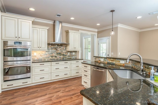 8460 Rockbridge Cir, Montgomery, AL 36116 - kitchen featuring stainless steel appliances, wall chimney exhaust hood, a sink, tasteful backsplash, and crown molding