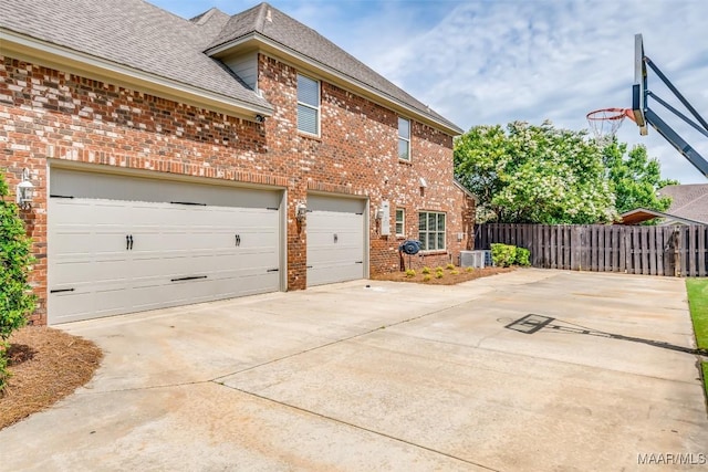 8460 Rockbridge Cir, Montgomery, AL 36116 - view of property exterior featuring brick siding, concrete driveway, a shingled roof, and central AC