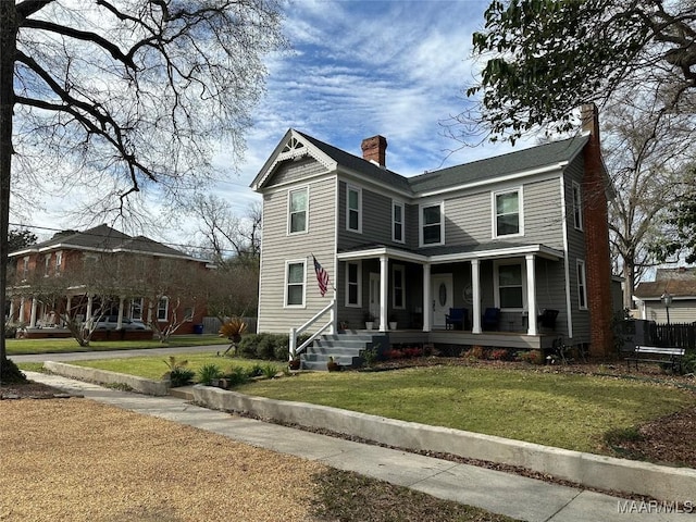 408 W Tuskeena St, Wetumpka, AL 36092 - view of front of home with a porch, a chimney, and a front lawn