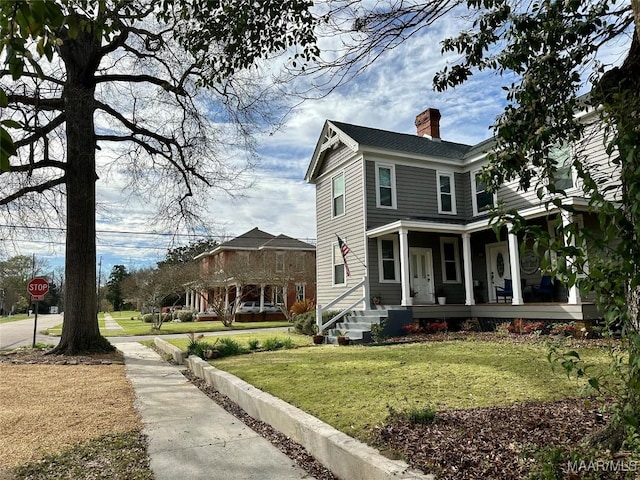408 W Tuskeena St, Wetumpka, AL 36092 - view of side of home featuring a chimney, covered porch, and a yard