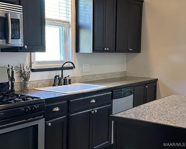 408 W Tuskeena St, Wetumpka, AL 36092 - kitchen featuring stainless steel appliances, dark cabinetry, and a sink