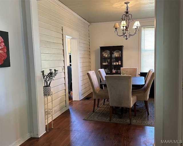 408 W Tuskeena St, Wetumpka, AL 36092 - dining room featuring a chandelier, hardwood / wood-style flooring, ornamental molding, wooden walls, and baseboards
