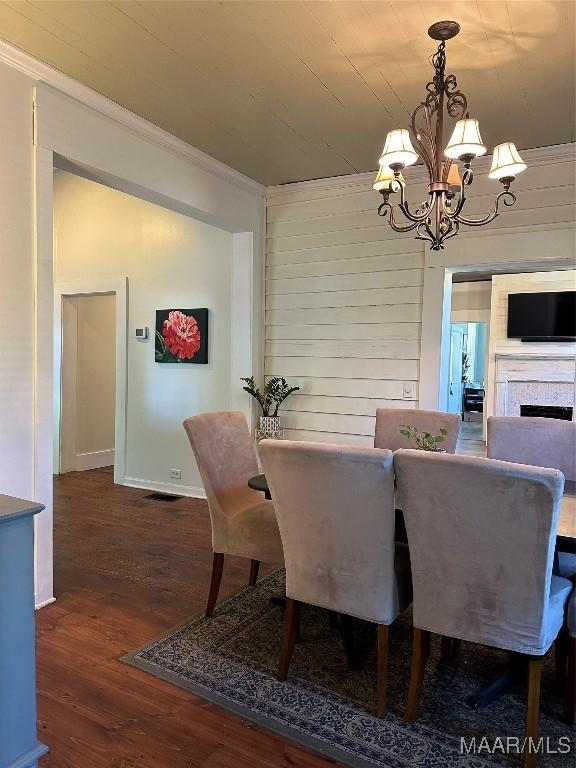 408 W Tuskeena St, Wetumpka, AL 36092 - dining room with crown molding, a chandelier, wood finished floors, baseboards, and a fireplace