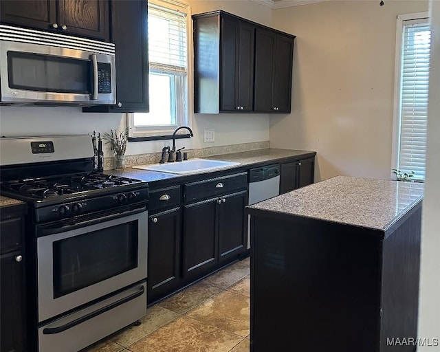 408 W Tuskeena St, Wetumpka, AL 36092 - kitchen featuring stainless steel appliances, a sink, crown molding, a kitchen island, and dark cabinets