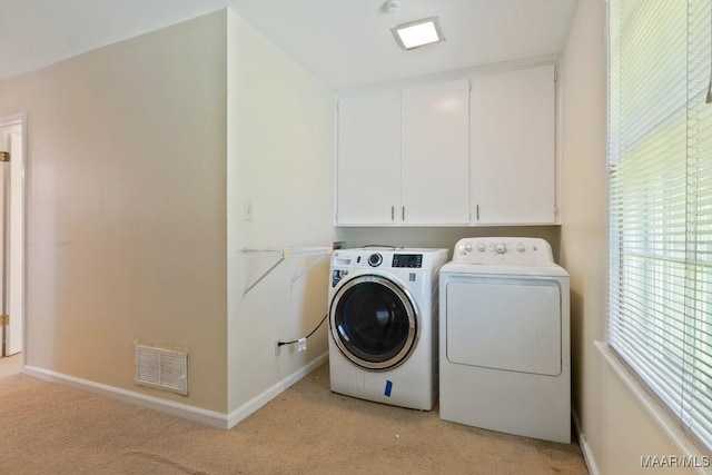 3158 Partridge Ln, Montgomery, AL 36111 - laundry area featuring washer and dryer, cabinet space, light colored carpet, and baseboards