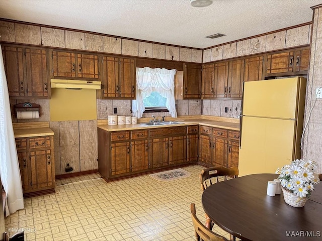 476 Hideaway Rd, Camden, AL 36726 - kitchen featuring freestanding refrigerator, brick patterned flooring, a sink, under cabinet range hood, and a textured ceiling
