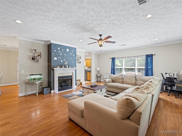 33 Glendale Acres Acres, Eclectic, AL 36024 - living room with light wood-style floors, crown molding, ceiling fan, a textured ceiling, and a fireplace