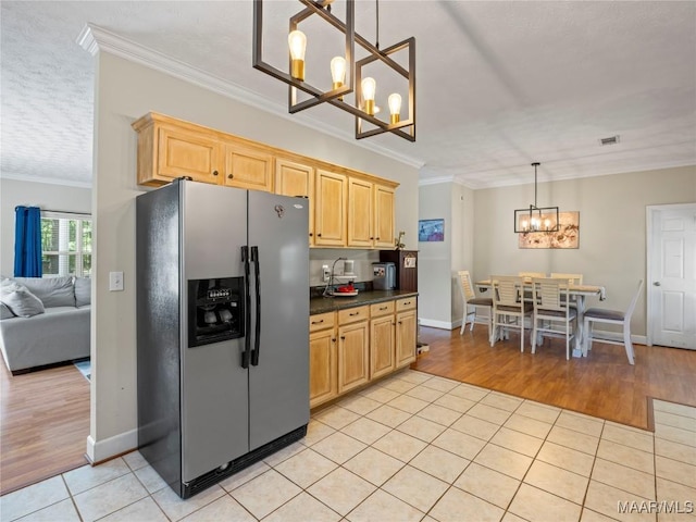 33 Glendale Acres Acres, Eclectic, AL 36024 - kitchen featuring stainless steel fridge with ice dispenser, a chandelier, ornamental molding, light tile patterned floors, and dark countertops