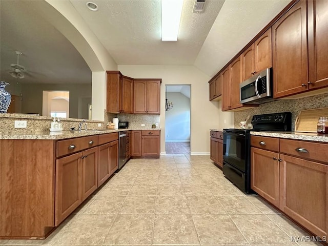 624 Stoneybrooke Way, Montgomery, AL 36117 - kitchen featuring stainless steel appliances, backsplash, a sink, brown cabinets, and baseboards