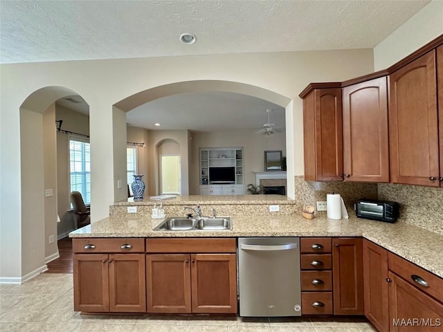 624 Stoneybrooke Way, Montgomery, AL 36117 - kitchen with stainless steel dishwasher, a sink, a ceiling fan, a peninsula, and light stone countertops