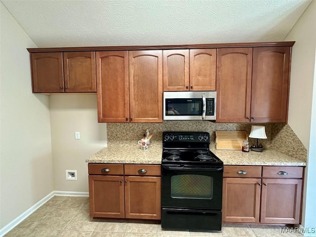 624 Stoneybrooke Way, Montgomery, AL 36117 - kitchen with stainless steel microwave, black range with electric stovetop, decorative backsplash, baseboards, and light stone counters