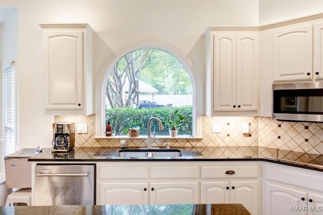 2261 Vaughn Ln, Montgomery, AL 36106 - kitchen featuring appliances with stainless steel finishes, dark countertops, a sink, and tasteful backsplash