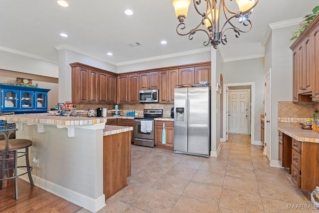 1900 Wyndgate Loop, Montgomery, AL 36117 - kitchen featuring appliances with stainless steel finishes, tasteful backsplash, a peninsula, a breakfast bar, and crown molding