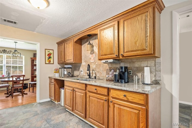 1505 Terrace Ct, Opelika, AL 36081 - kitchen with a sink, brown cabinets, tasteful backsplash, baseboards, and a textured ceiling