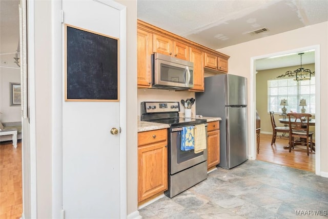 1505 Terrace Ct, Opelika, AL 36081 - kitchen featuring appliances with stainless steel finishes, a chandelier, and baseboards